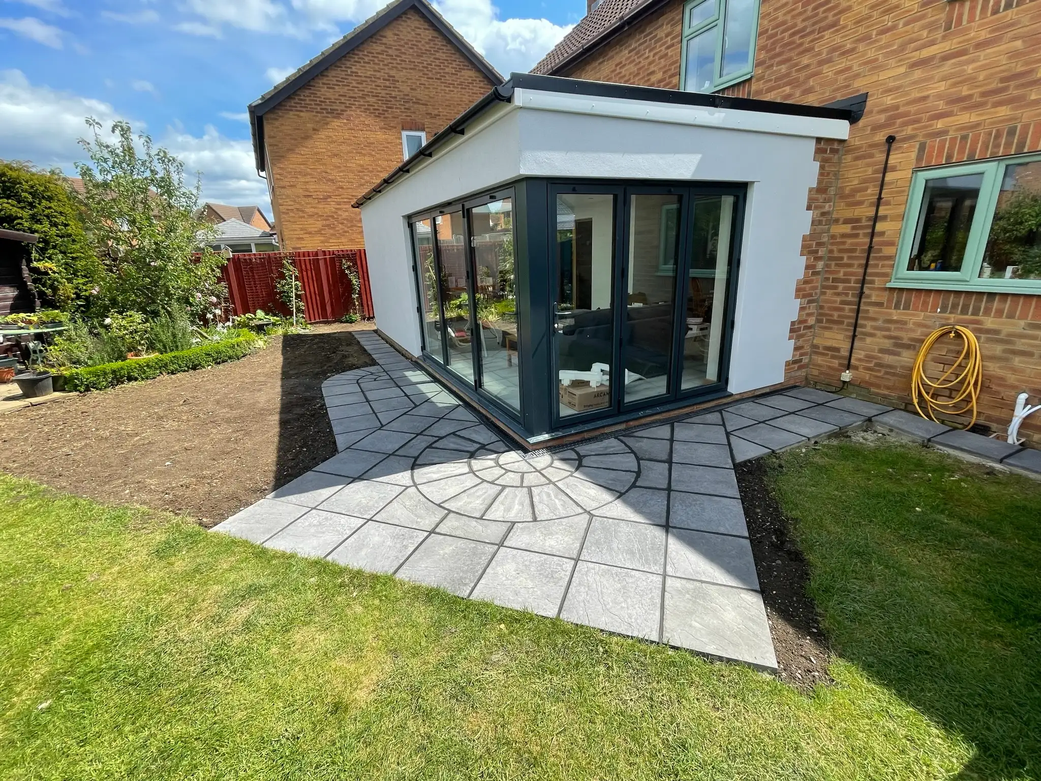 Glazed corner extension and sandstone patio by Ablewood